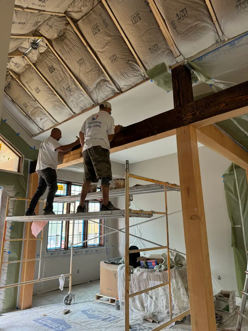 Life As Color painters working from scaffolding on a timber-frame ceiling