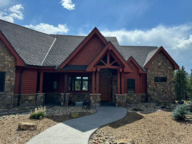 Mountain home with freshly painted rust-red siding and stone base